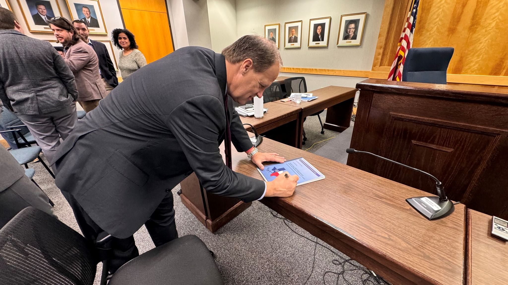 PUCT Commissioner Jimmy Glotfelty signs a copy of the just-published Texas Advanced Nuclear Reactor Working Group Report and Policy Recommendations.