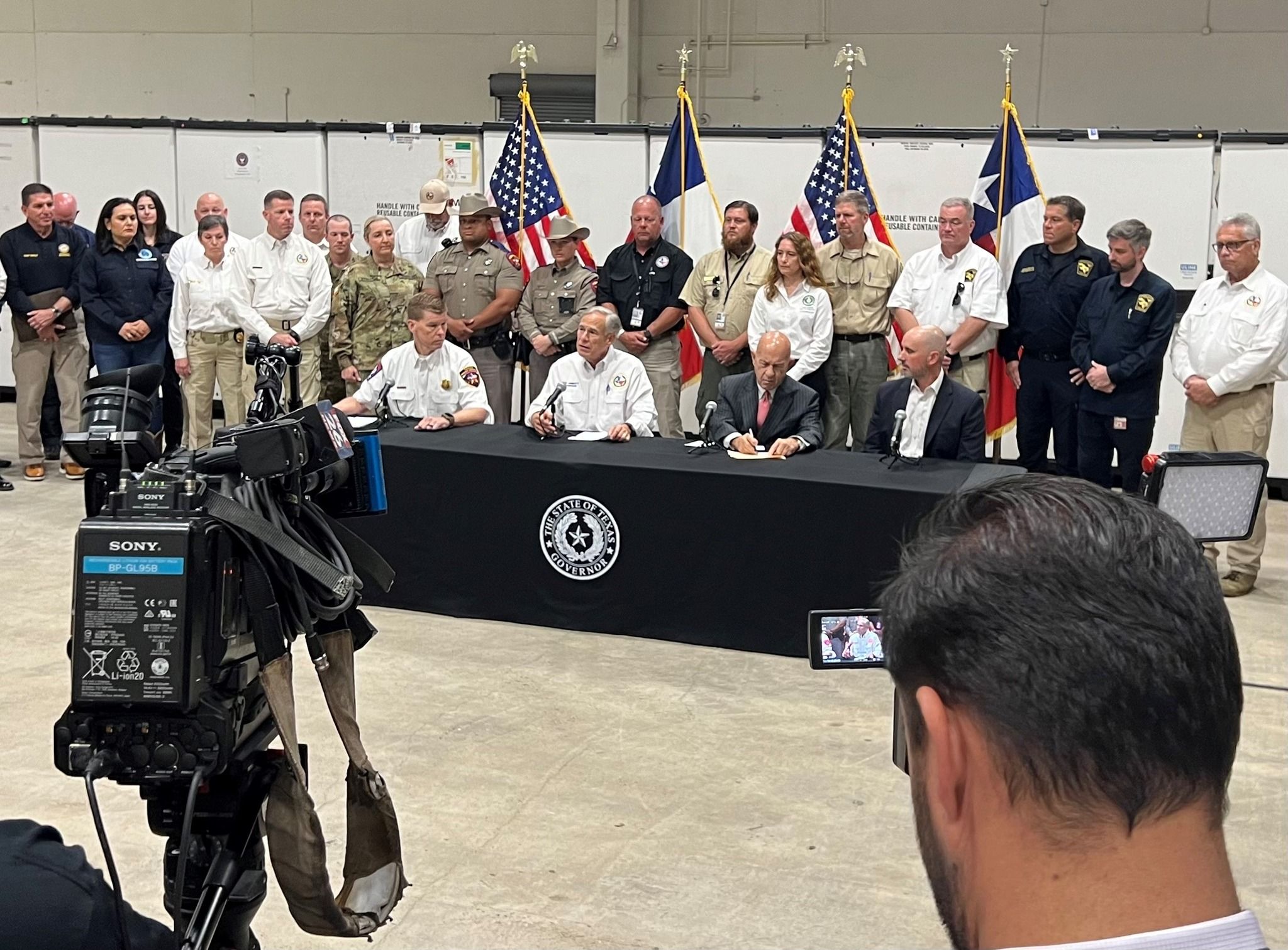 PUCT Chairman Thomas Gleeson (far right, seated) and Commissioner Lori Cobos (far left, standing) join Gov. Greg Abbott and local and state leaders on Hurricane Beryl recovery in Houston.