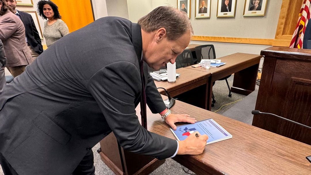 PUCT Commissioner Jimmy Glotfelty signs a copy of the just-published Texas Advanced Nuclear Reactor Working Group Report and Policy Recommendations.